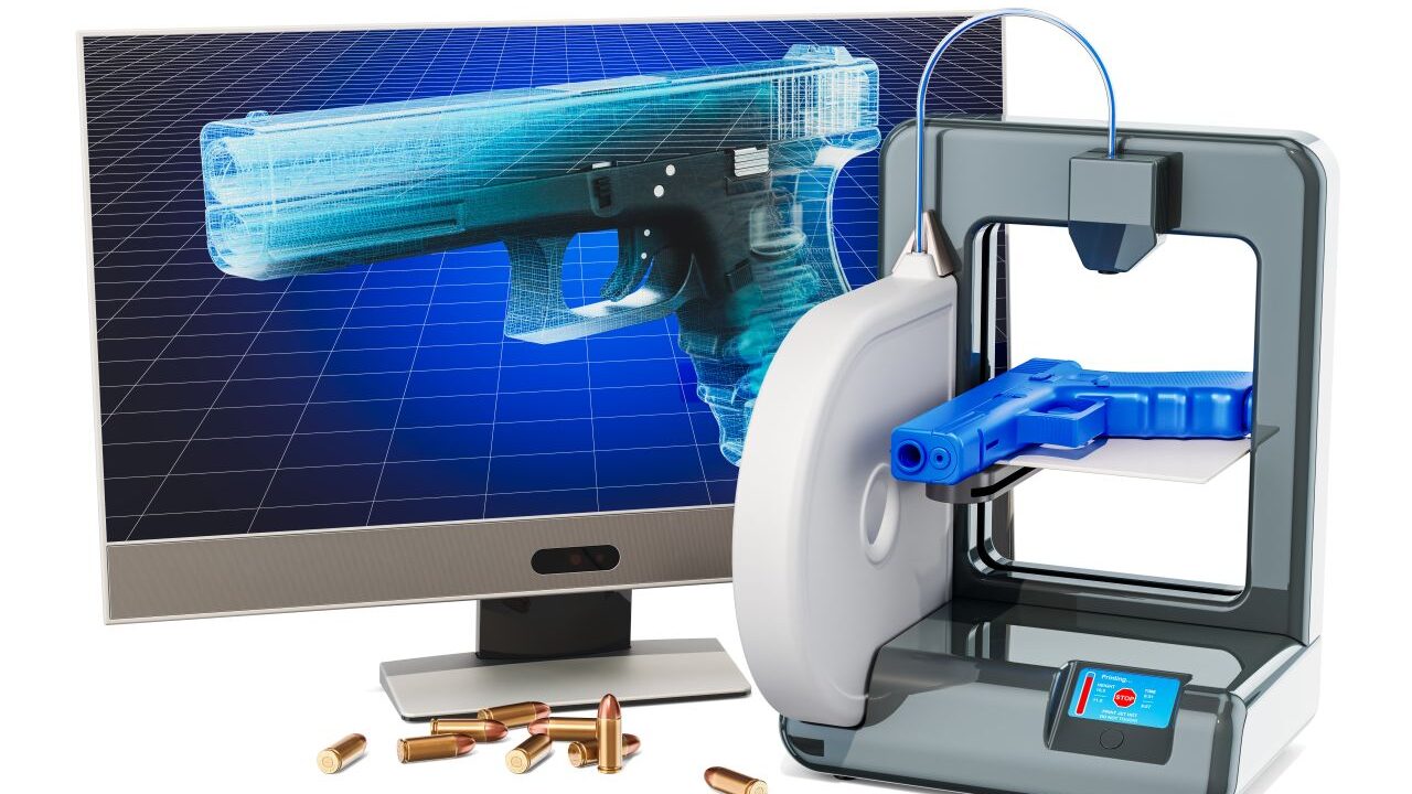 Image of a ghost gun firearm on a computer screen next to a 3-D printer