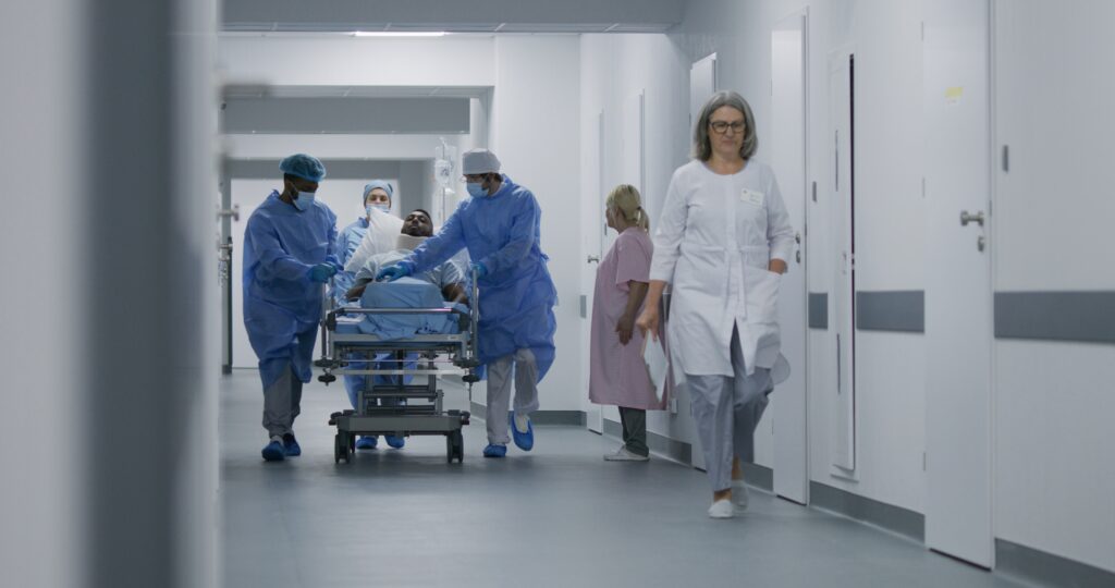 Image of a patient on a gurney being rushed down a hospital hall