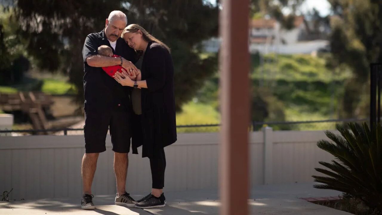 Image of foster care parents holding a 3-month-old baby