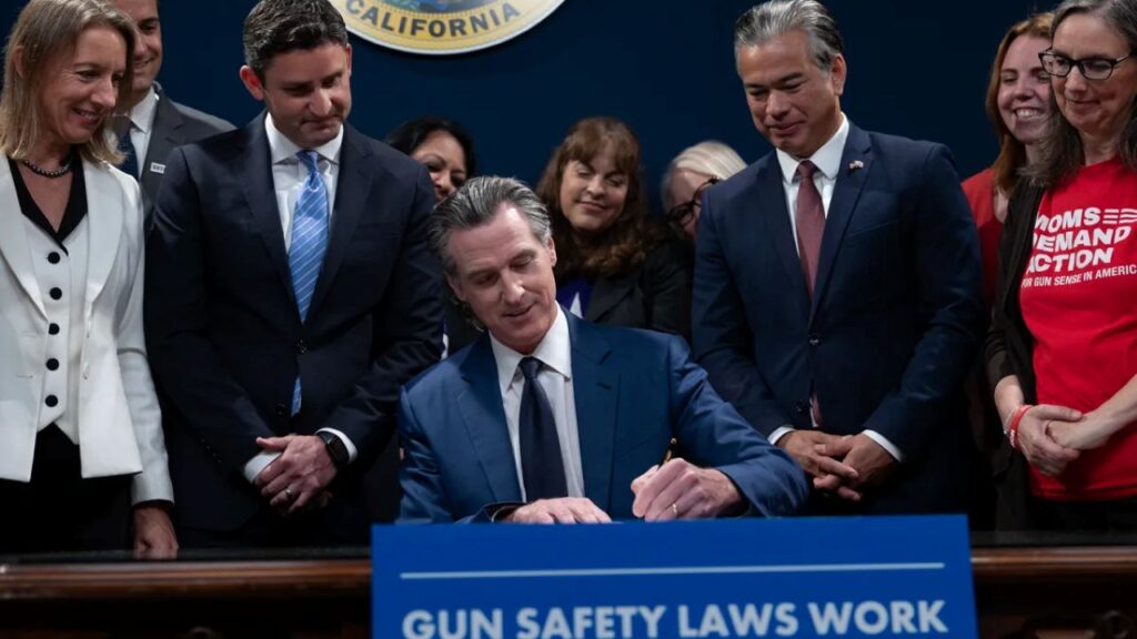Image of Gavin Newsom signing a gun safety bill at the state Capitol