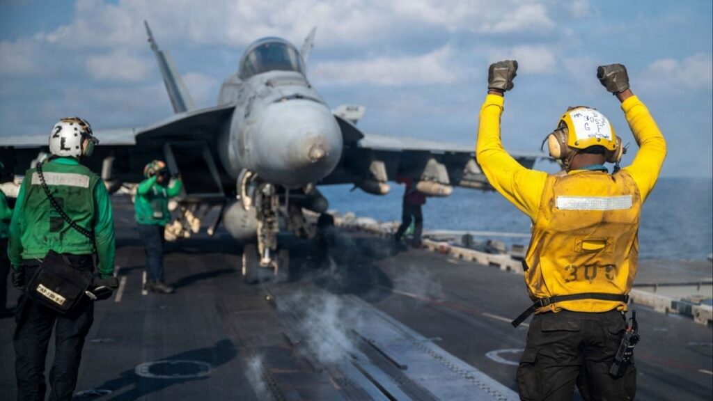 A U.S. Navy sailor signals an F/A-18E Super Hornet on the flight deck of the Nimitz-class aircraft carrier USS Abraham Lincoln in support of the Operation Epic Fury attack on Iran at an undisclosed location March 4, 2026. (Reuters File)
