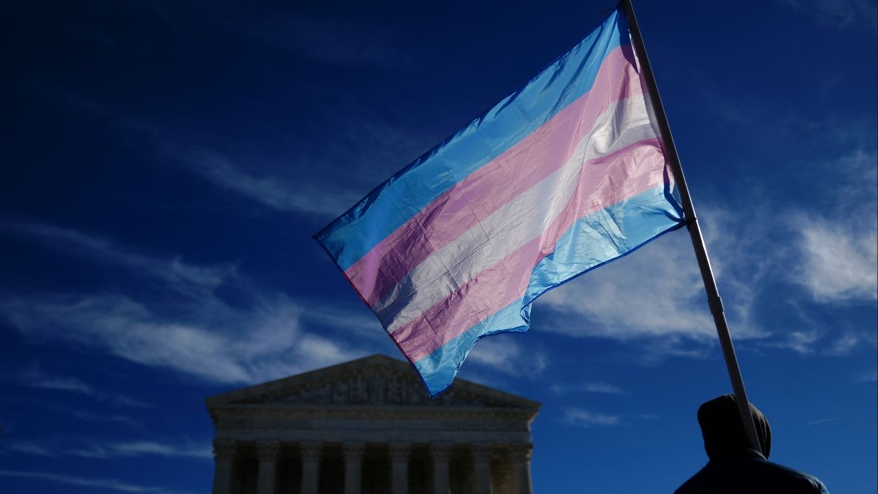 A demonstrator carries a transgender pride flag outside the U.S. Supreme Court as the court hears arguments concerning transgender athletes participating in girls’ sports in Washington, Jan. 13, 2026. The Supreme Court on Monday, March 2, 2026, sided with a group of religious parents, temporarily blocking California from using policies that generally bar public-school teachers from outing transgender students to their parents. (Tierney L. Cross/The New York Times)