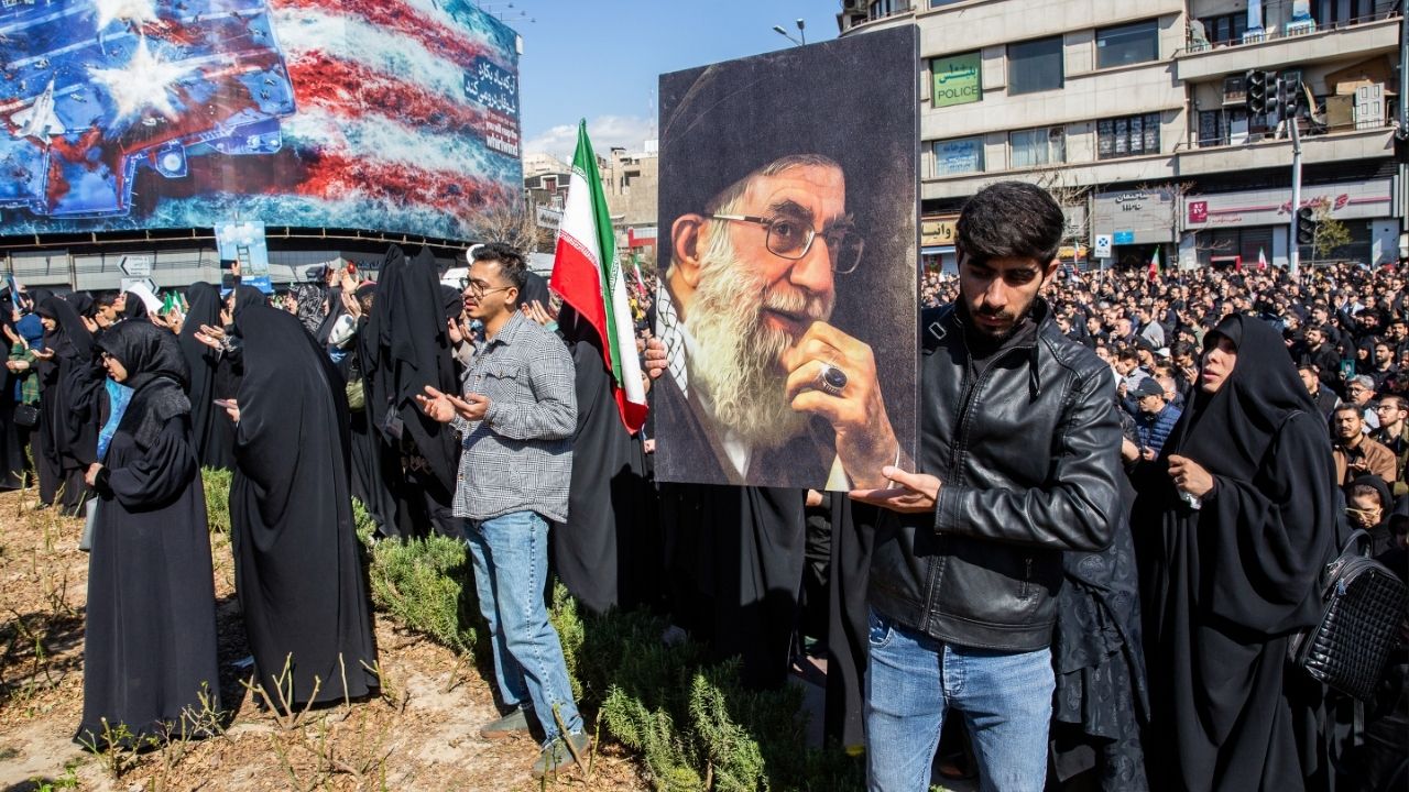 A man holds a photo of Iran’s supreme leader, Ayatollah Ali Khamenei, as people mourn his killing at a rally in Tehran, Iran, on Sunday, March 1, 2026, a day after he was killed in coordinated U.S. and Israeli airstrikes. The senior clerics responsible for selecting Iran’s next supreme leader met on Tuesday to deliberate, and the son of the slain former leader emerged as the clear front-runner, according to three Iranian officials familiar with the deliberations. (Arash Khamooshi/The New York Times)