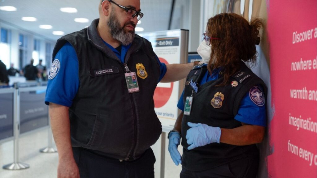 A pair of TSA officers talk as passengers wait in long TSA lines amid a funding standoff that has forced 50,000 airport security officers to go without pay, causign delays at airports, at the George Bush Intercontinental Airport in Houston, Texas, U.S., March 25, 2026. (Reuters/Antranik Tavitian)