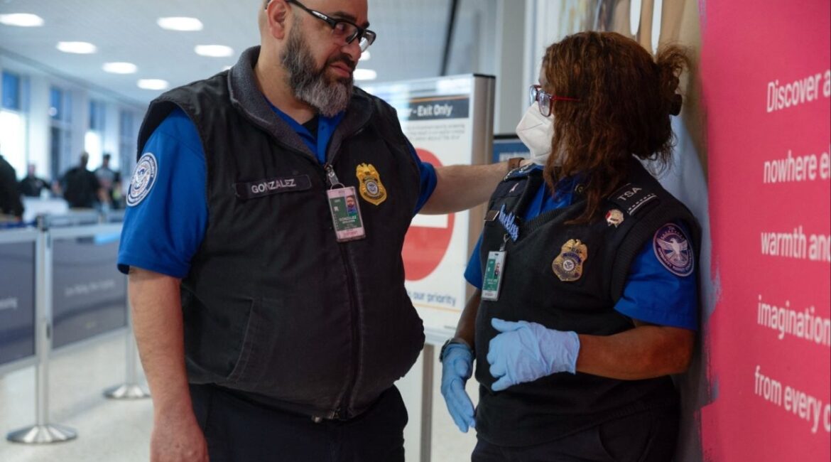A pair of TSA officers talk as passengers wait in long TSA lines amid a funding standoff that has forced 50,000 airport security officers to go without pay, causign delays at airports, at the George Bush Intercontinental Airport in Houston, Texas, U.S., March 25, 2026. (Reuters/Antranik Tavitian)