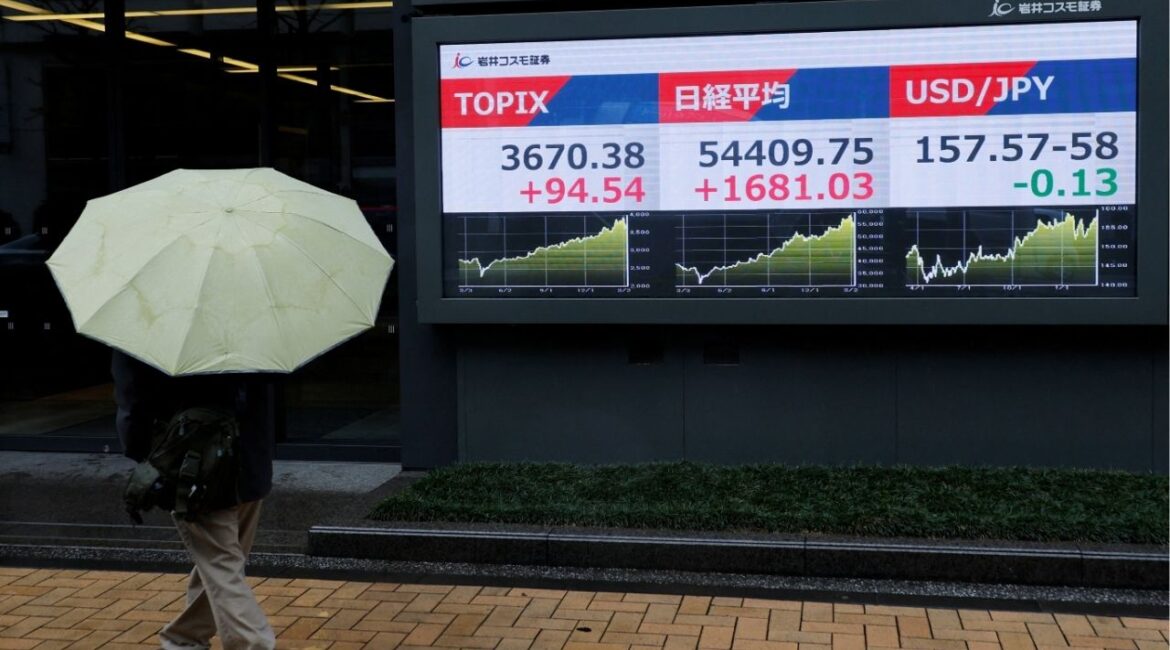 A pedestrian looks at a stock quotation board showing the Topix average, the Nikkei share average and the exchange rate between Japanese yen and U.S. dollar outside a brokerage in Tokyo, Japan, March 10, 2026. (Reuters/Kim Kyung-Hoon)