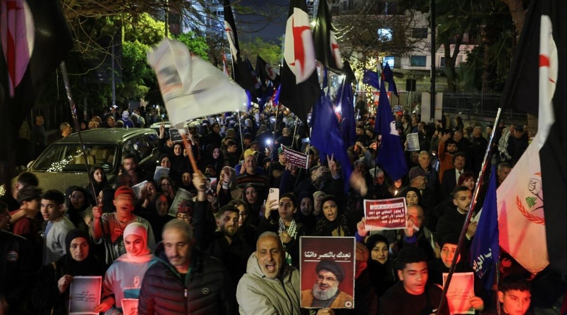 A person raises a portrait of late Hezbollah leader Hassan Nasrallah during a demonstration in support of Hezbollah and Iran, amid escalating hostilities between Israel and Hezbollah, as the U.S.-Israeli conflict with Iran continues, in Beirut, Lebanon, March 27, 2026. (Reuters/Amr Abdallah Dalsh)