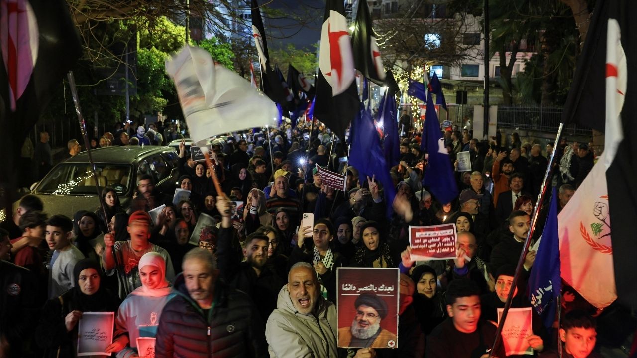 A person raises a portrait of late Hezbollah leader Hassan Nasrallah during a demonstration in support of Hezbollah and Iran, amid escalating hostilities between Israel and Hezbollah, as the U.S.-Israeli conflict with Iran continues, in Beirut, Lebanon, March 27, 2026. (Reuters/Amr Abdallah Dalsh)