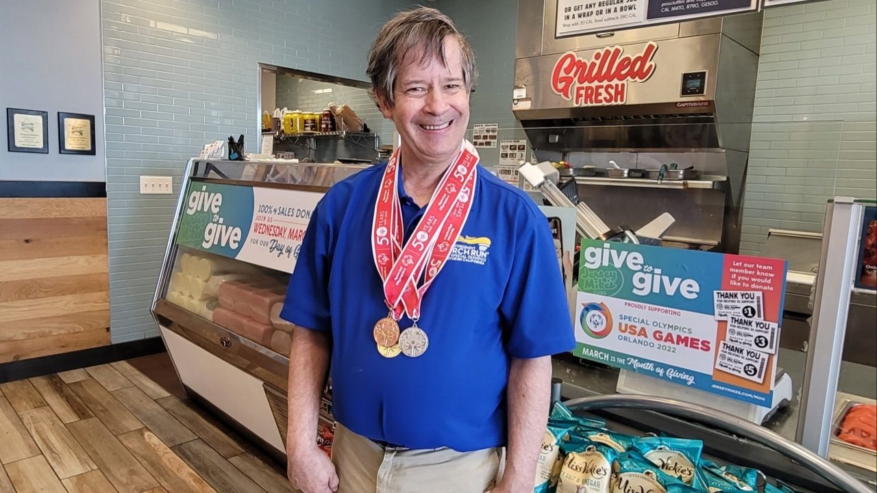A special Olympic athlete poses with his medals at a Jersey Mike's. (SONC.org)