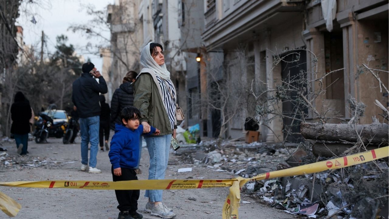 A woman with her child looks at the aftermath of an Israeli and the U.S. strike on a police station, amid the U.S.-Israel conflict with Iran, in Tehran, Iran, March 2, 2026. (Majid Asgaripour/WANA (West Asia News Agency) via Reuters)