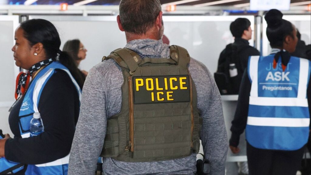 An Immigration and Customs Enforcement (ICE) agent stands while air travellers wait in TSA Security lines at John F. Kennedy International Airport, Queens, New York City, U.S., March 27, 2026. (Reuters/Shannon Stapleton)