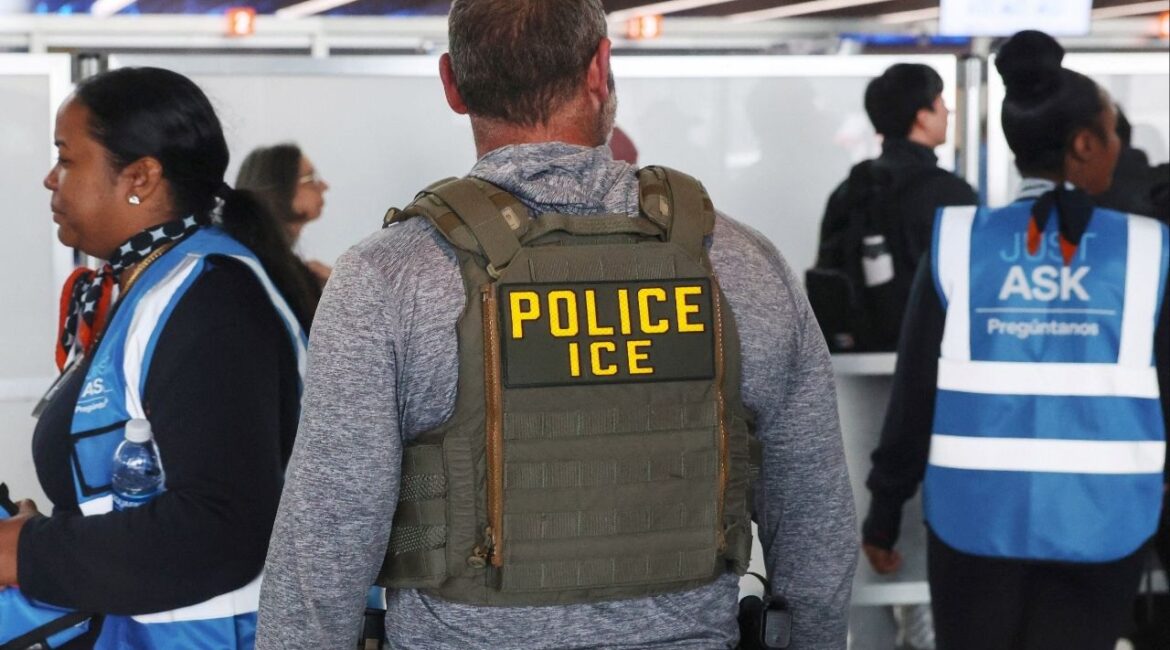 An Immigration and Customs Enforcement (ICE) agent stands while air travellers wait in TSA Security lines at John F. Kennedy International Airport, Queens, New York City, U.S., March 27, 2026. (Reuters/Shannon Stapleton)