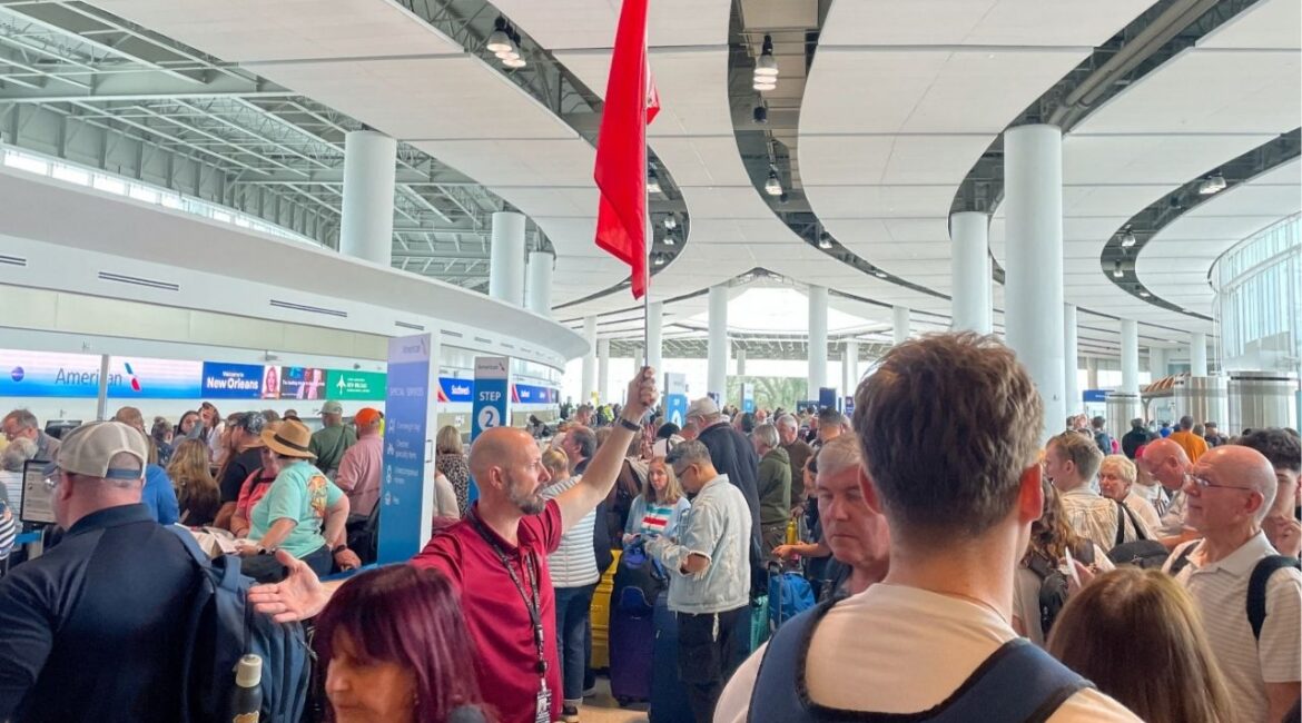An airport official directs passengers at Louis Armstrong New Orleans International Airport, in Kenner, Louisiana, U.S., March 8, 2026. (Reuters/David Gaffen)