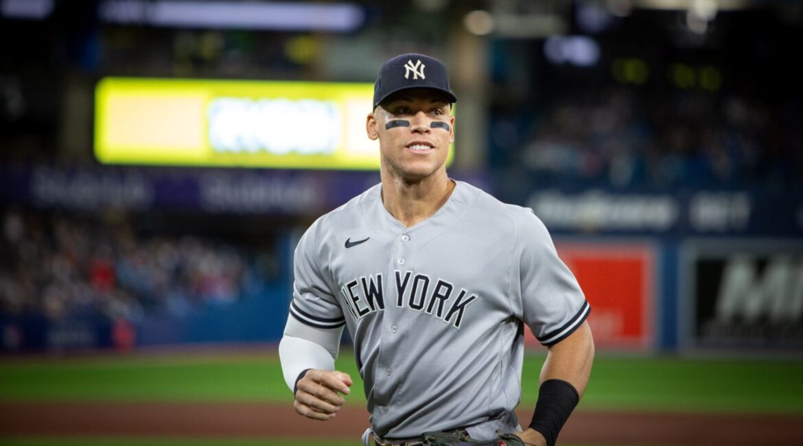 Image of New York Yankees star Aaron Judge running off the field in a night game