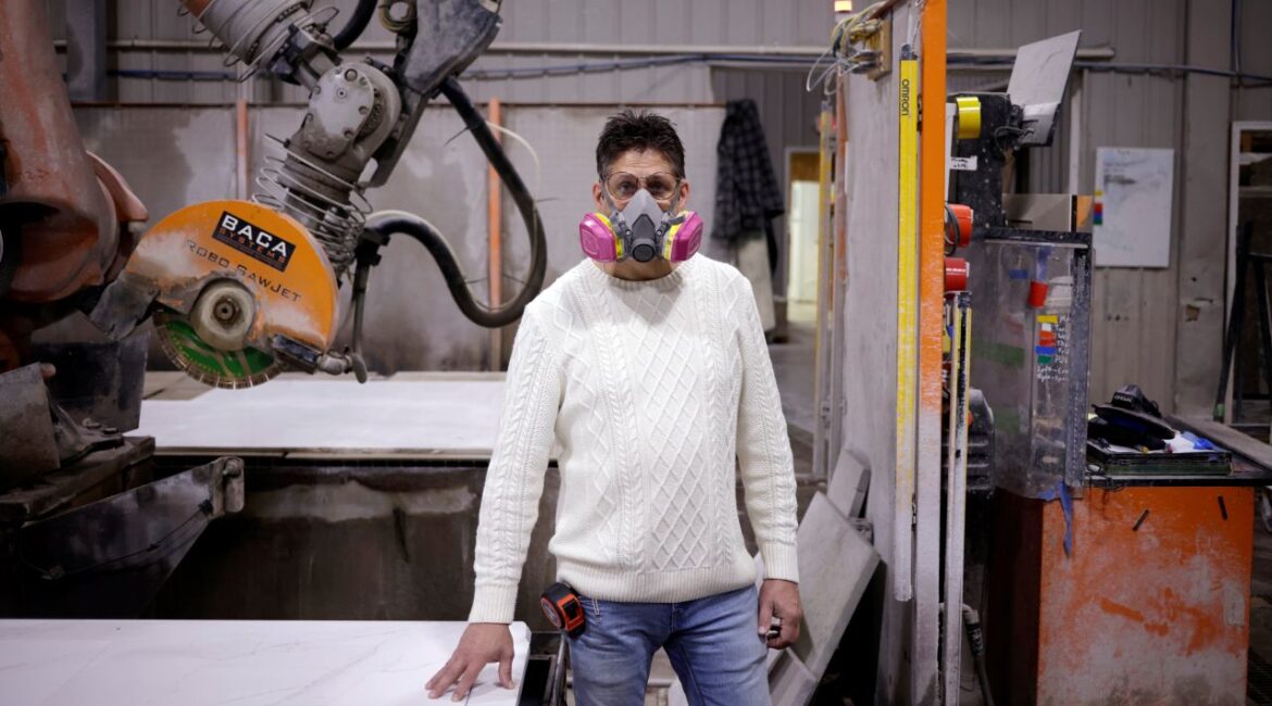 Image of man wearing a mask in a shop that cuts engineered stone such as quartz