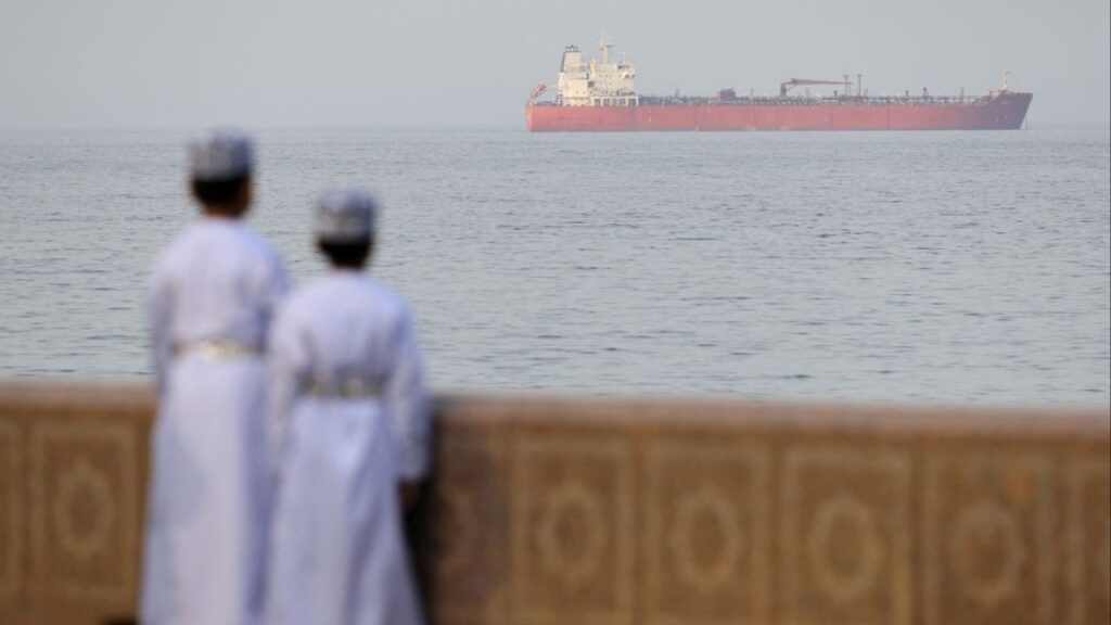 Children stand on the waterfront overlooking a tanker at anchor, amid the U.S.-Israeli conflict with Iran, off the coast of Muscat, Oman, March 18, 2026. (Reuters/Stelios Misinas TPX IMAGES OF THE DAY)