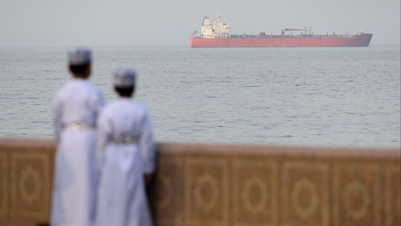 Children stand on the waterfront overlooking a tanker at anchor, amid the U.S.-Israeli conflict with Iran, off the coast of Muscat, Oman, March 18, 2026. (Reuters/Stelios Misinas TPX IMAGES OF THE DAY)