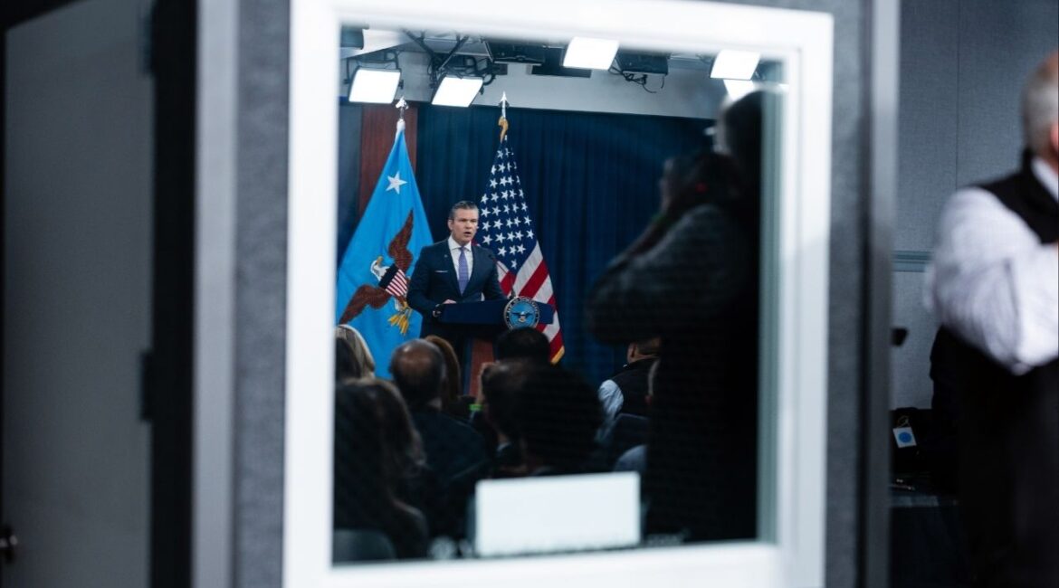 Defense Secretary Pete Hegseth is reflected in a window as he speaks to reporters during a press briefing at the Pentagon in Arlington, Va., on Tuesday, March 31, 2026. Hegseth conceded on Tuesday that Iran retains the ability to retaliate despite a monthlong U.S.-Israeli bombing campaign but repeated claims that Iran’s military capabilities had been severely degraded, in his first public briefing on the war in nearly two weeks. (Eric Lee/The New York Times)