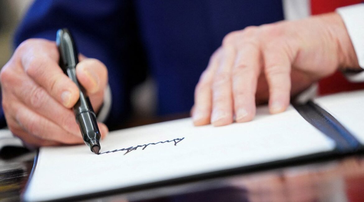 FILE PHOTO: U.S. President Donald Trump writes his signature, as he signs executive orders and proclamations in the Oval Office at the White House in Washington, D.C., U.S., April 9, 2025. REUTERS/Nathan Howard/File Photo