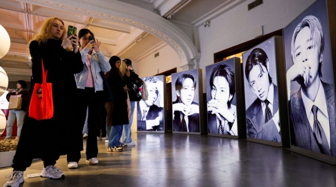 Fans of Kpop boy band BTS, known as ARMY, photograph portraits of the members at a pop-up exhibition ahead of the group's upcoming free comeback concert, "BTS The Comeback Live Arirang," their first performance in more than three years following the completion of mandatory military service, in Seoul, South Korea, March 20, 2026. (Reuters/Kim Soo-hyeon)