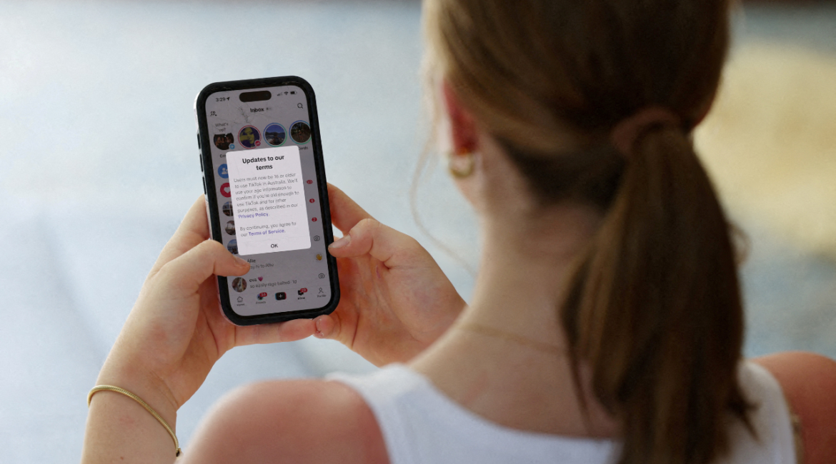 A teenager poses holding a mobile phone displaying a message from TikTok as law banning social media for users under 16 in Australia takes effect, in Sydney, Australia, December 10, 2025. (Reuters File)