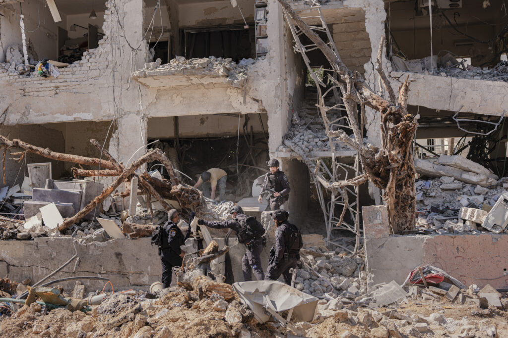 Image of Israeli officials inspecting the site of an Iranian missile strike in Tel Aviv