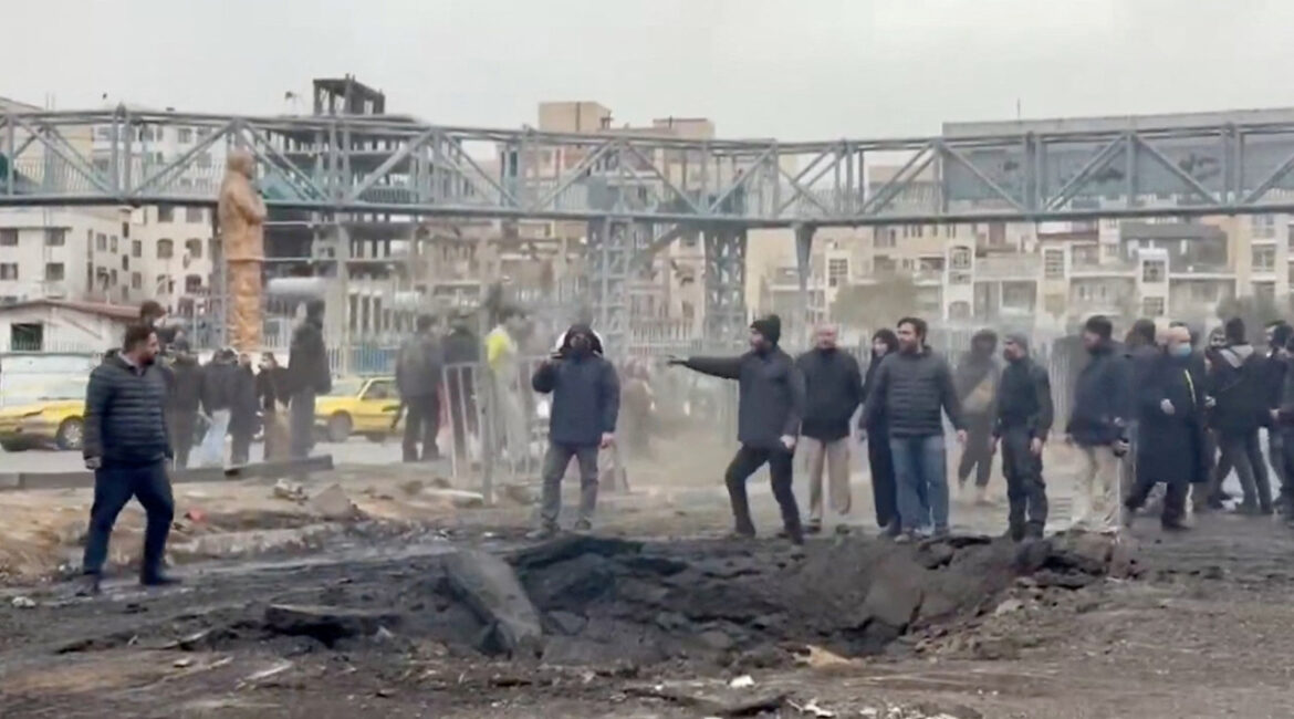 People stand at an affected area on the street, following a reported strike, amid the U.S.-Israeli conflict with Iran, in Tehran, Iran, in this screengrab from a a handout video released March 10, 2026. (Iranian Red Crescent Society/Handout via Reuters)