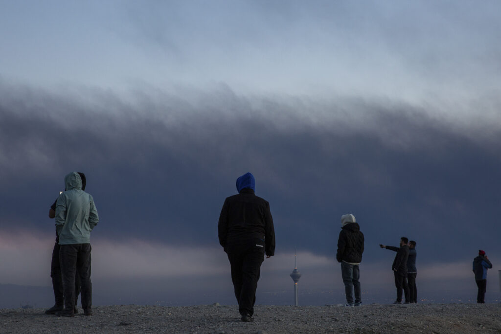 Image of residents in Tehran gathering at a high location to look over the city amid U.S..-Israeli missile strikes
