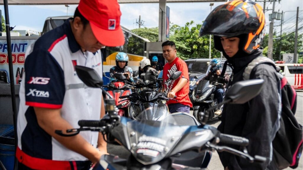 Motorcycle drivers queue while a worker fills up a motorcycle at a gas station as oil prices are expected to increase amid the U.S.-Israel conflict with Iran, in Quezon City, Metro Manila, Philippines, March 9, 2026. (Reuters/Lisa Marie David)