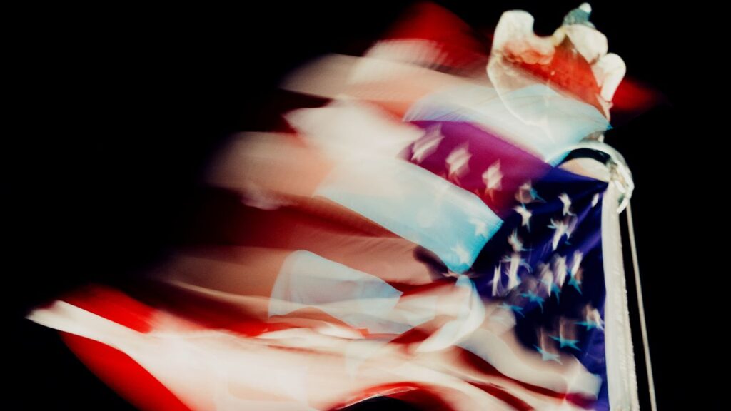 Distorted color image of the US flag blowing in the wind outside the US Supreme Court at night