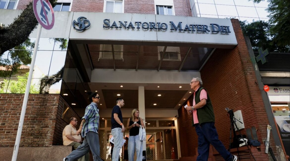 People stand outside Sanatorio Mater Dei, where AC/DC guitarist Stevie Young has been hospitalised, in Buenos Aires, Argentina, March 19, 2026. (Reuters File)