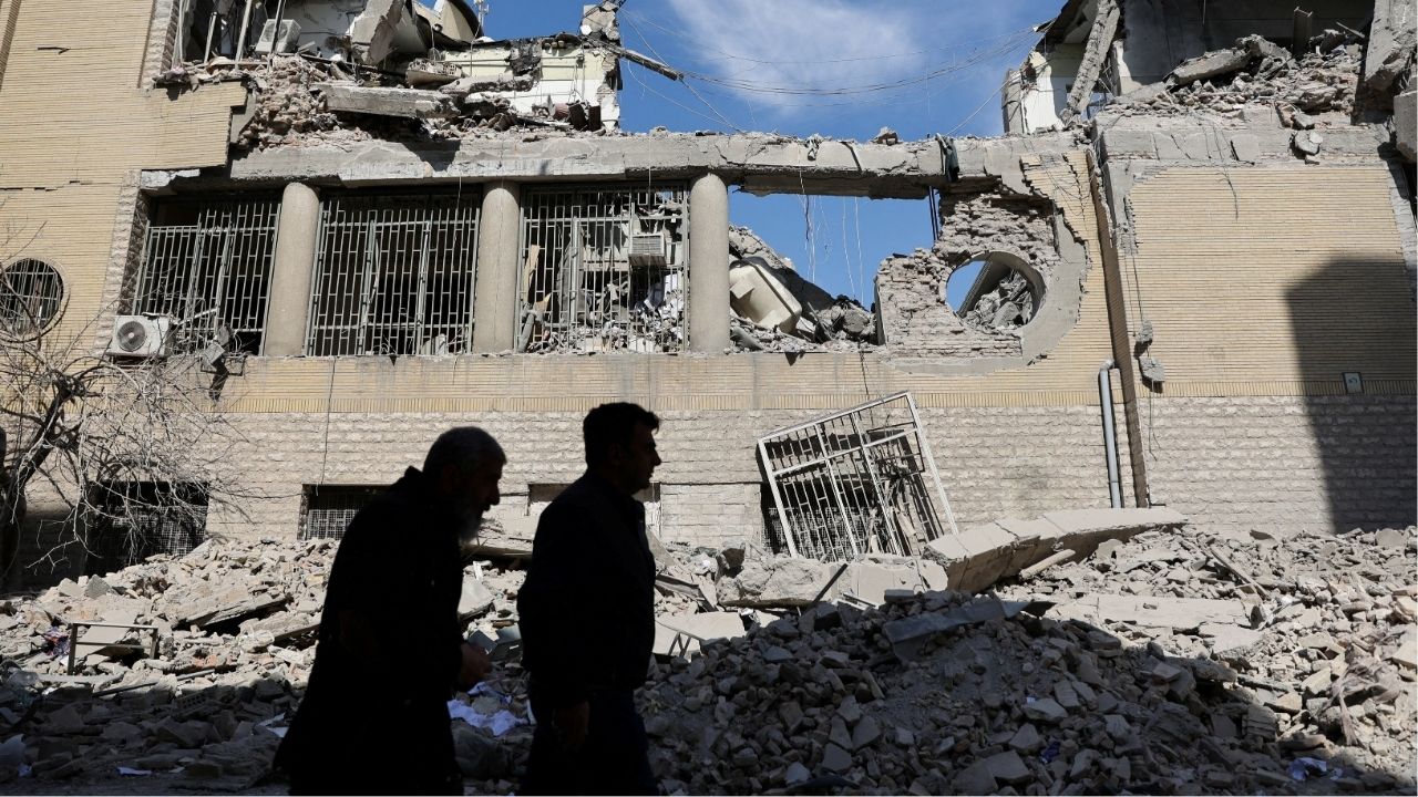 People walk past damaged buildings following a strike on a police station, amid the U.S.-Israeli conflict with Iran, in Tehran, Iran, March 4, 2026. (Majid Asgaripour/WANA (West Asia News Agency) via Reuters)