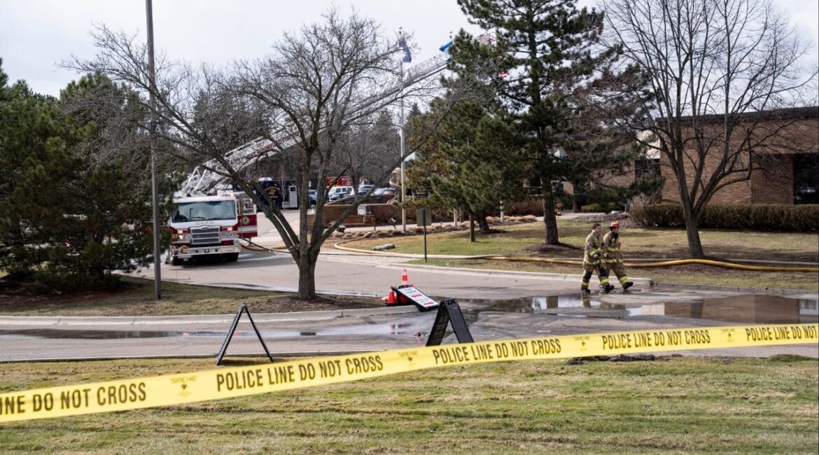 Police officers and firefighters at the scene where a truck was rammed into Temple Israel, a synagogue in West Bloomfield Township, Mich., March 12, 2026. An attacker is dead after plowing a vehicle into a synagogue on Thursday outside Detroit and then exchanging gunfire with security guards in what the authorities described as a “targeted act of violence against the Jewish community.” (Sarah Rice/The New York Times)