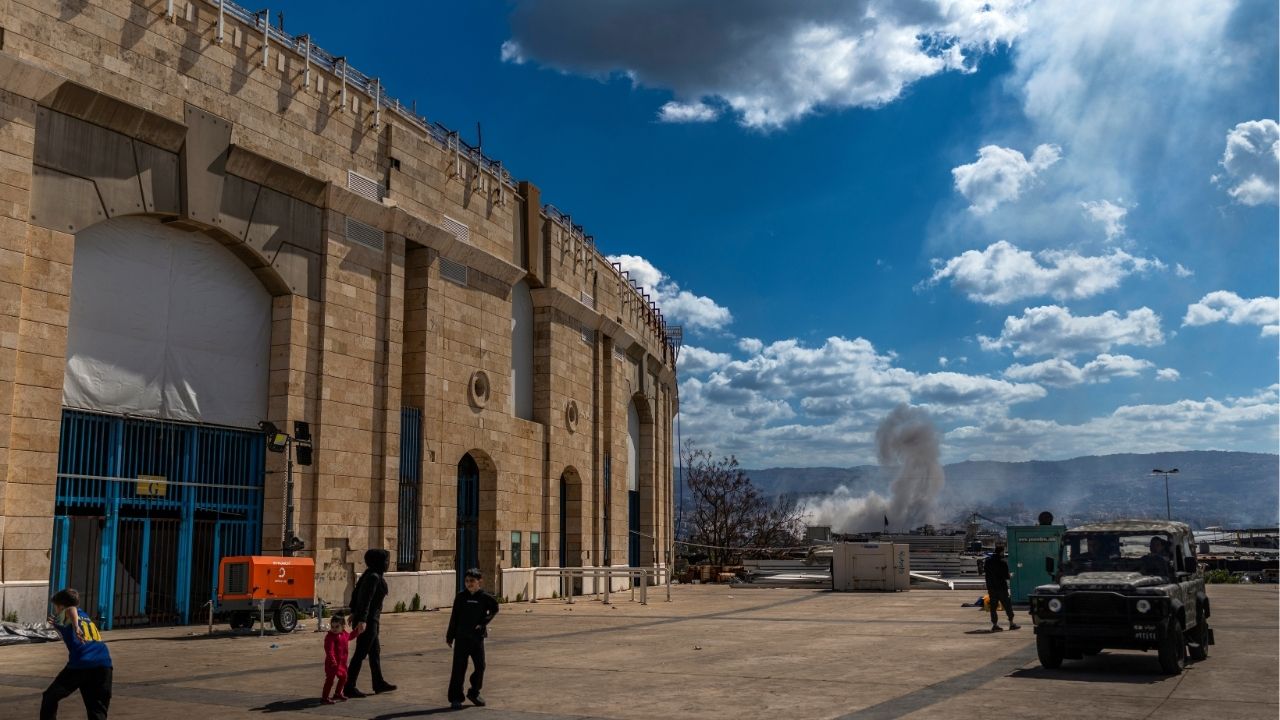 Smoke billows after an Israeli airstrike, as seen from an emergency shelter for displaced families at the Camille Chamoun Sports City Stadium in Beirut, Lebanon, on Monday, March 9, 2026. Israeli forces advanced in southern Lebanon on Monday, raiding new territory as part of a stated effort to expand a military-controlled buffer zone as it steps up its campaign against the Iran-backed armed group Hezbollah. (Diego Ibarra Sánchez/The New York Times)