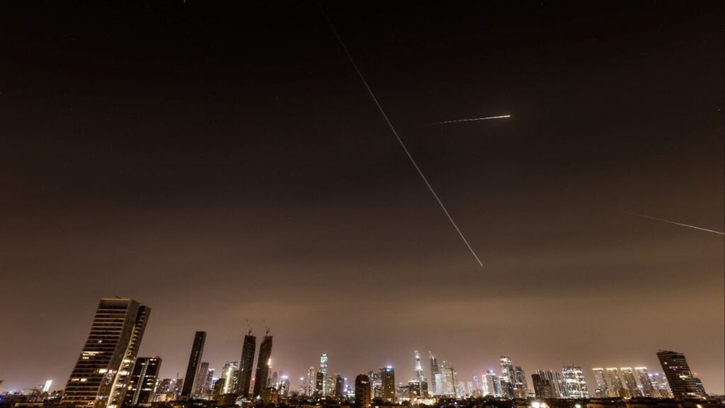 Streaks of light and a flying aircraft illuminate the sky during an interception attempt amid the U.S.-Israeli conflict with Iran, as seen from Tel Aviv, Israel, March 21, 2026. REUTERS/Amir Cohen