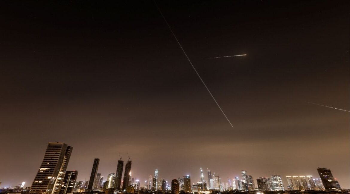 Streaks of light and a flying aircraft illuminate the sky during an interception attempt amid the U.S.-Israeli conflict with Iran, as seen from Tel Aviv, Israel, March 21, 2026. REUTERS/Amir Cohen