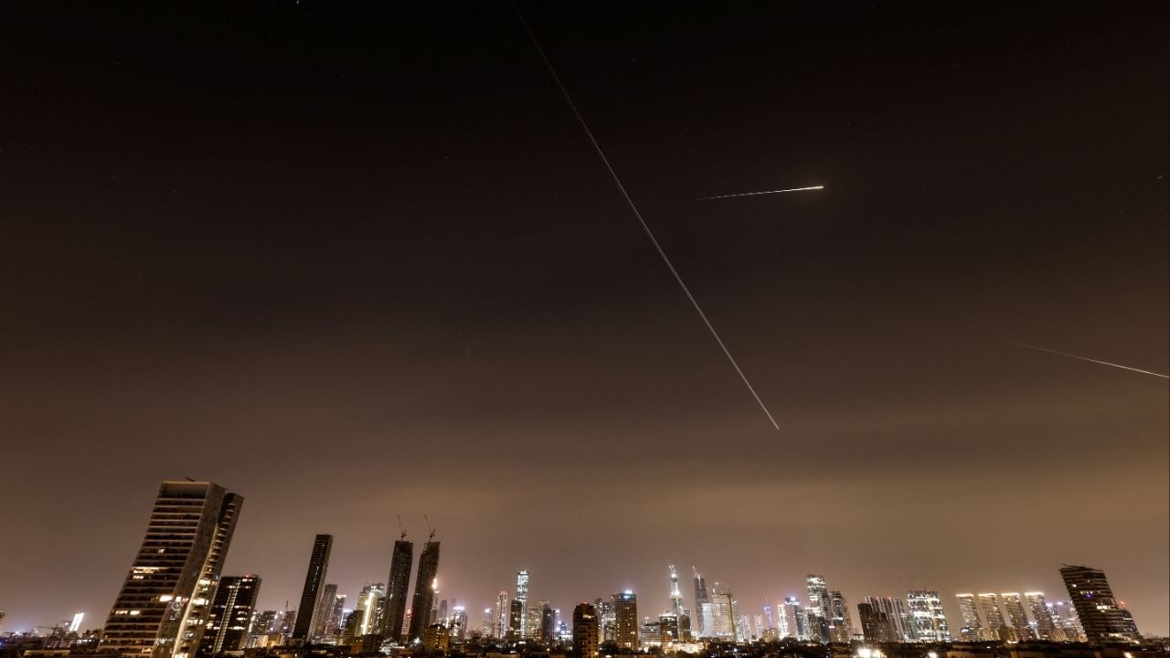 Streaks of light and a flying aircraft illuminate the sky during an interception attempt amid the U.S.-Israeli conflict with Iran, as seen from Tel Aviv, Israel, March 21, 2026. REUTERS/Amir Cohen