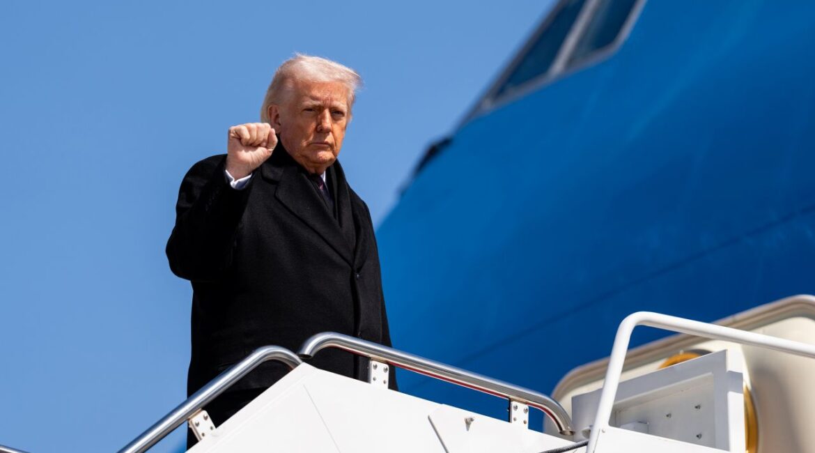 Image of President Trump in a black coat boarding Air Force One