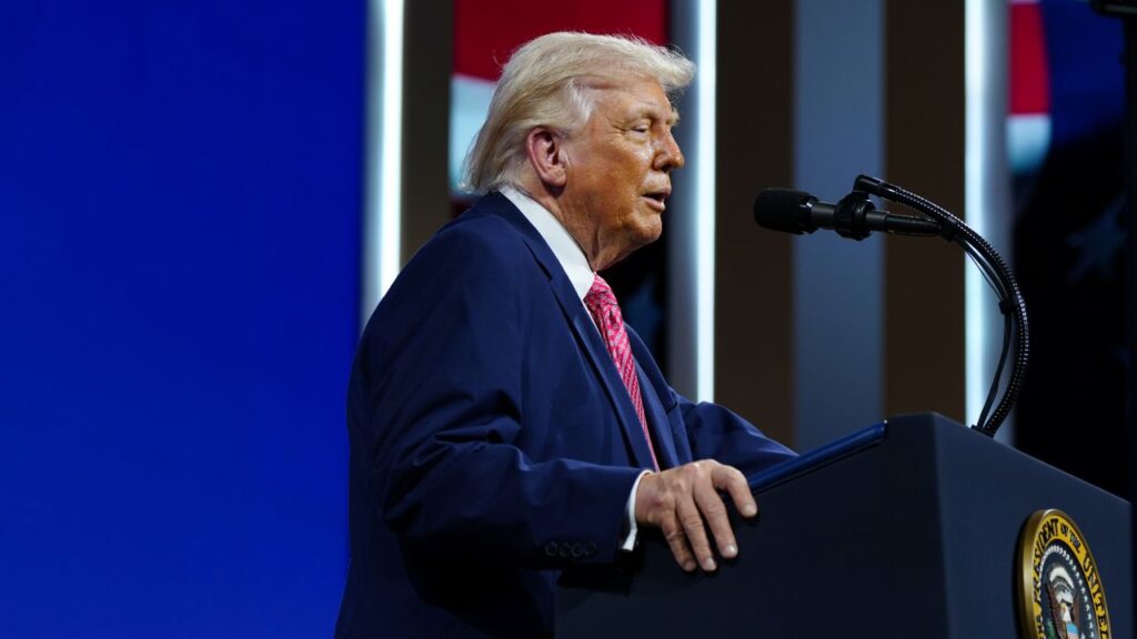 Image of President Trump in a blue suit, red tie and white shirt, speaking