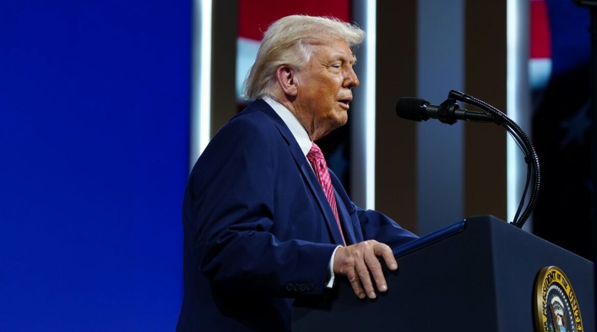 Image of President Trump in a blue suit, red tie and white shirt, speaking
