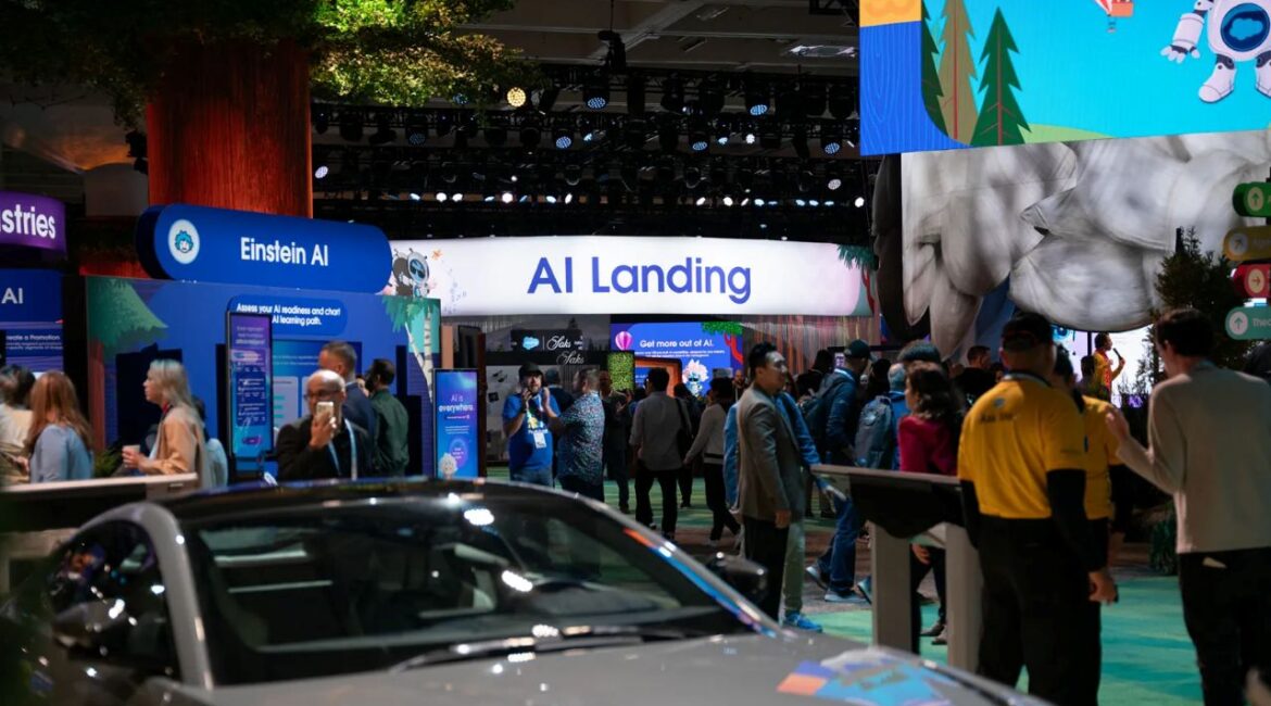 Image of a tech conference exhibit hall filled with spectators checking out cars and AI software