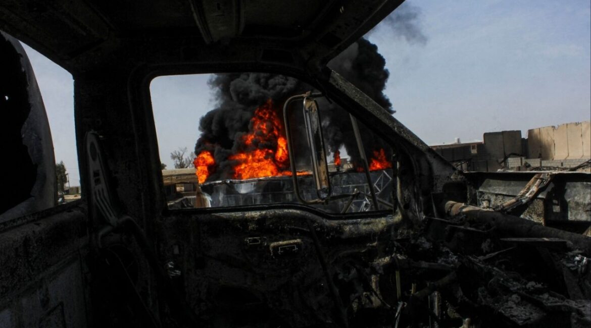 Thick black smoke is seen through a destroyed truck at the private airline Kam Air's fuel depot after a strike in what the Taliban said was a Pakistani air strike, in Kandahar, Afghanistan, March 13, 2026. (Reuters/Stringer)