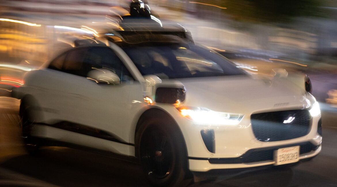 Image of a Waymo self-driving taxi on a San Francisco street at night