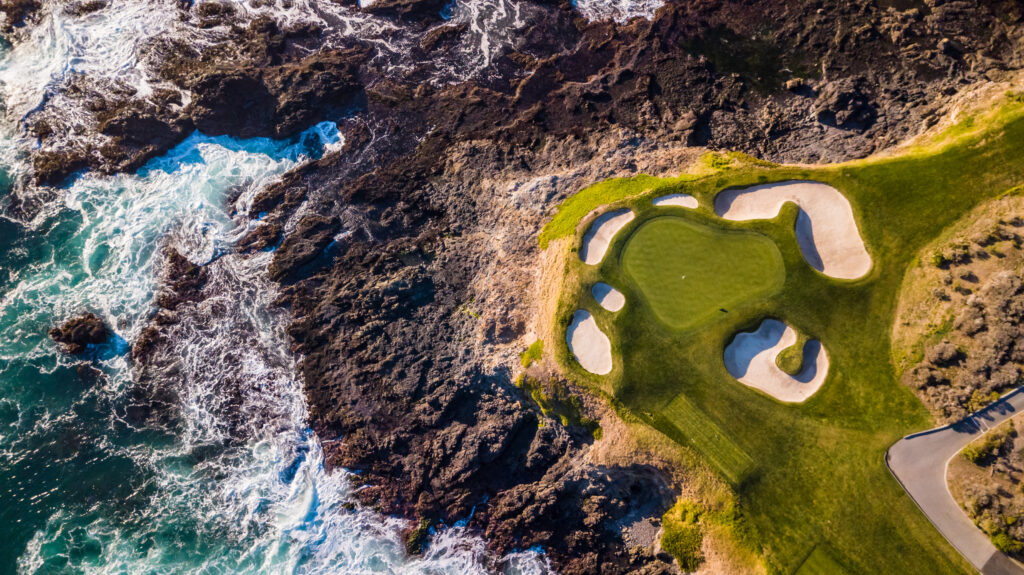 Drone view of a hole at Pebble Beach golf course next to the Pacific Ocean