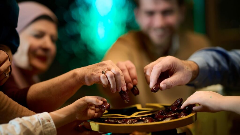 Image of a Muslim family celebrating the end of Ramadan with tradition of sharing a tray of dates