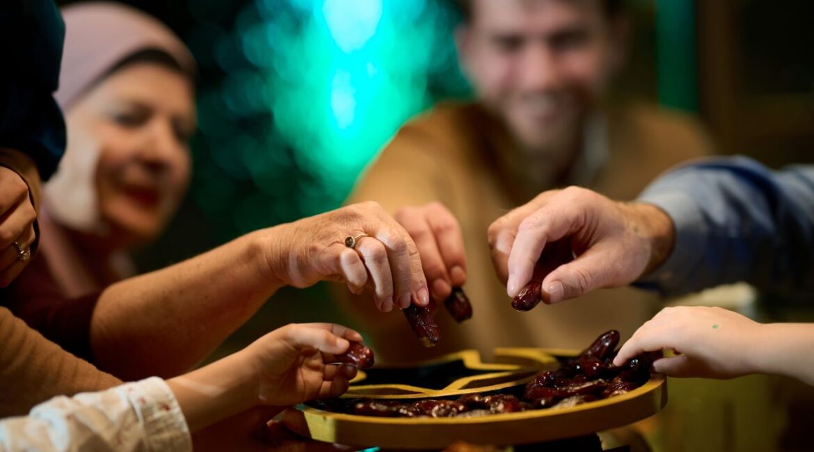 Image of a Muslim family celebrating the end of Ramadan with tradition of sharing a tray of dates