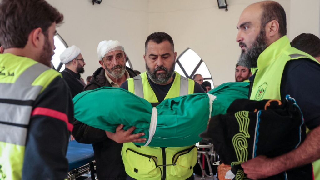 Image of a Lebanese defense official carrying the wrapped body of an infant