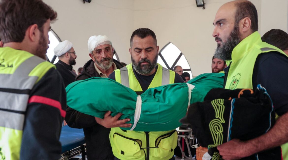 Image of a Lebanese defense official carrying the wrapped body of an infant