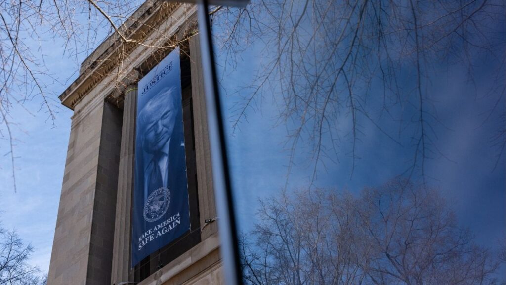 A banner bearing the face of President Donald Trump hangs from the Department of Justice building in Washington, Feb. 20, 2026. The Southern Poverty Law Center, a civil rights group, said on Tuesday that it was under investigation by the Justice Department over its past use of paid informants to infiltrate extremist groups. (Eric Lee/The New York Times)