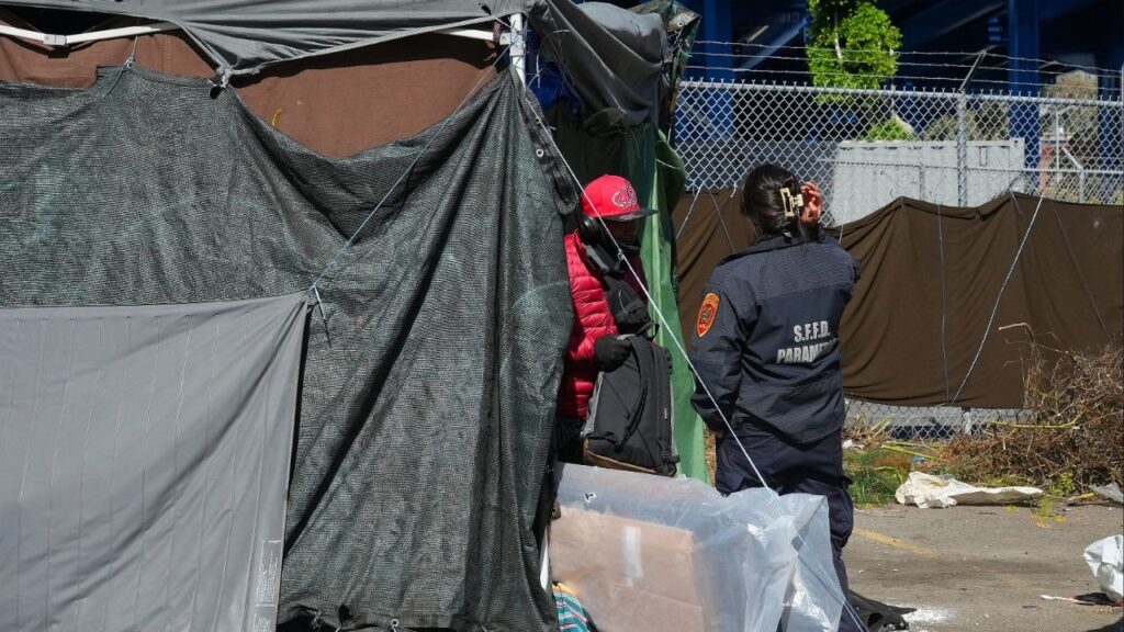 A paramedic speaks with a homeless man in San Francisco, Aug. 1, 2024. A federal judge on Tuesday, March 31, 2026, ruled that the Trump administration had illegally demanded that groups seeking homelessness grants comply with its agenda on immigration enforcement, transgender rights and other unrelated issues. (Jim Wilson/The New York Times)